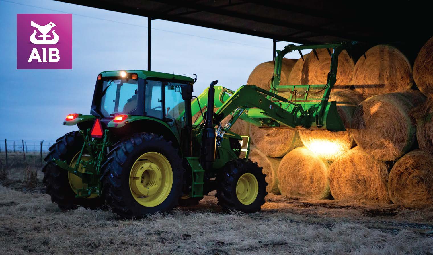 tractor stacking hay bails